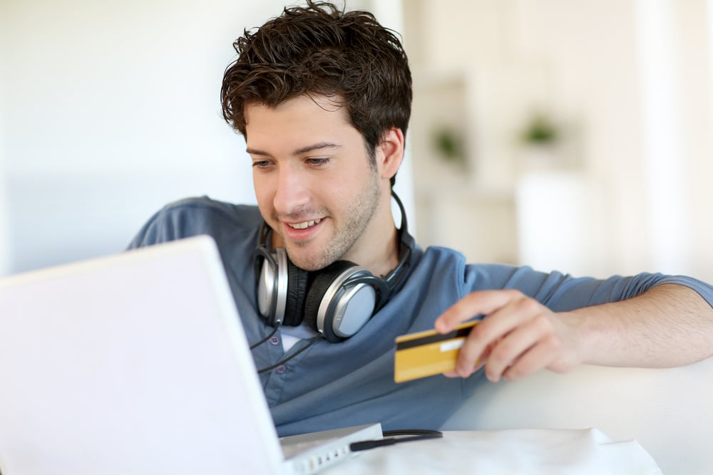 Young man buying music on internet with tablet